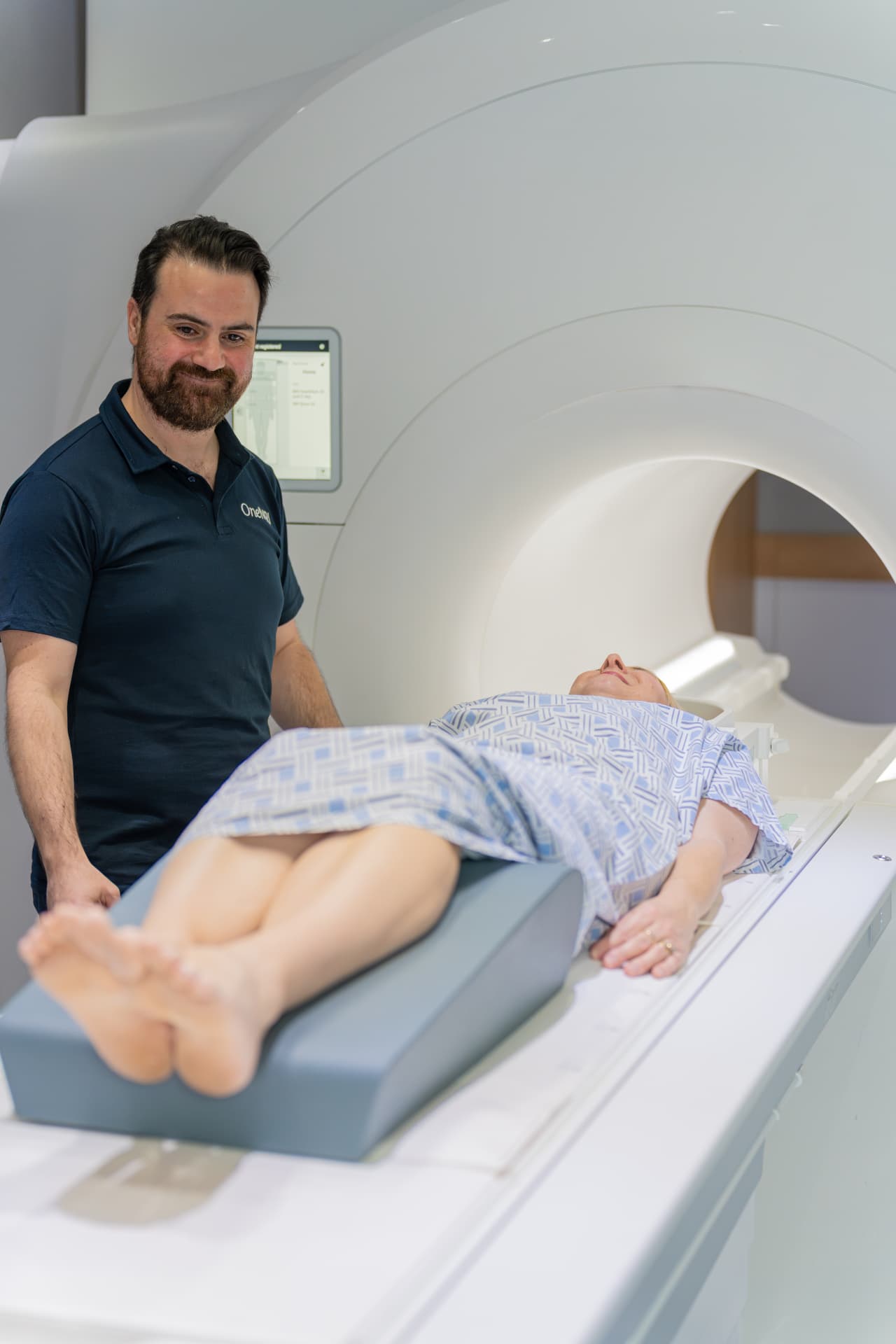 OneMRI radiographer assisting a patient with an MRI scan